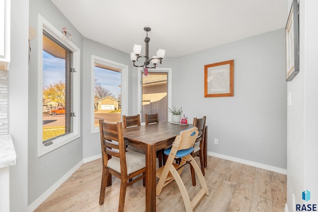 dining space featuring an inviting chandelier and light hardwood / wood-style flooring