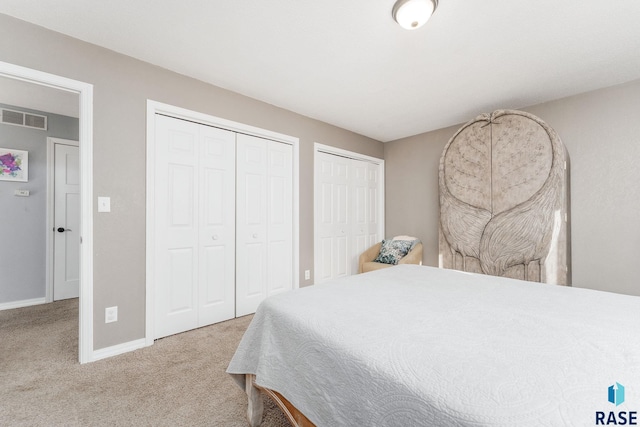 bedroom featuring multiple closets and carpet flooring