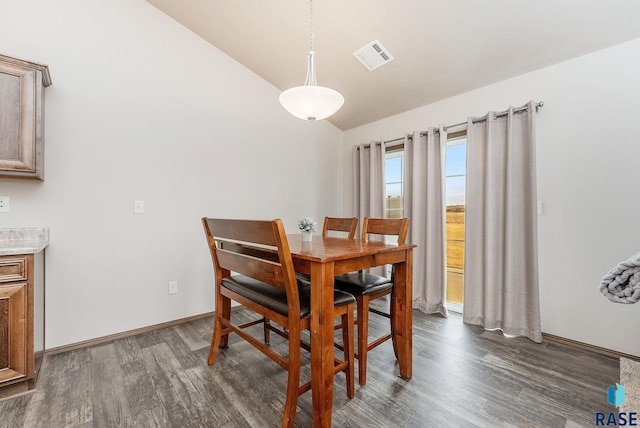 dining room featuring lofted ceiling and dark hardwood / wood-style flooring