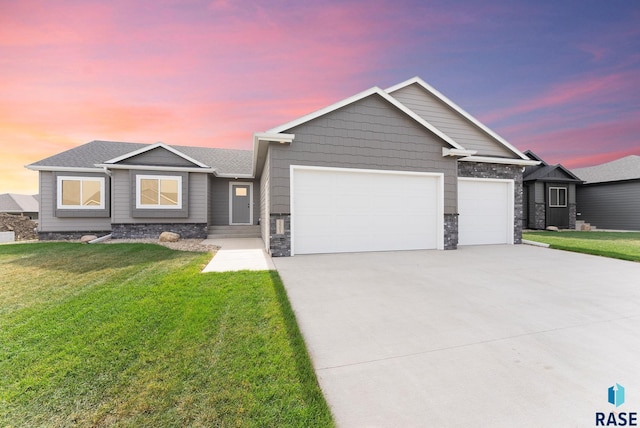 craftsman inspired home featuring a garage and a lawn