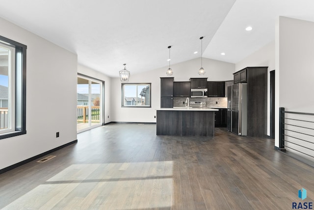 kitchen with a kitchen island with sink, decorative light fixtures, stainless steel appliances, and dark hardwood / wood-style floors