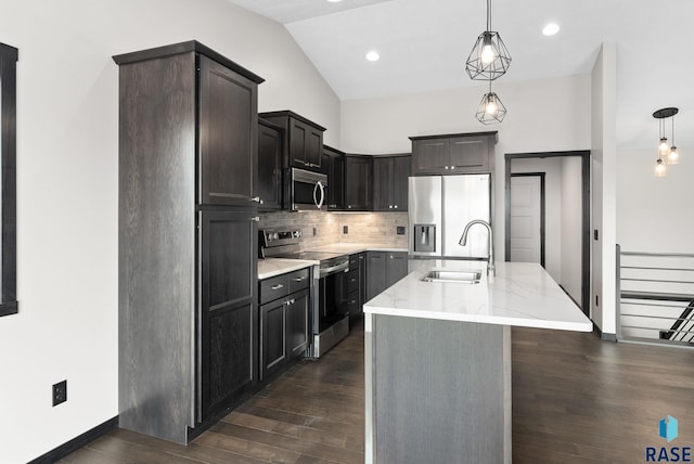 kitchen featuring an island with sink, appliances with stainless steel finishes, sink, and hanging light fixtures