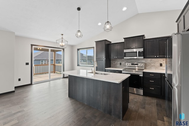 kitchen featuring pendant lighting, sink, appliances with stainless steel finishes, dark hardwood / wood-style floors, and an island with sink