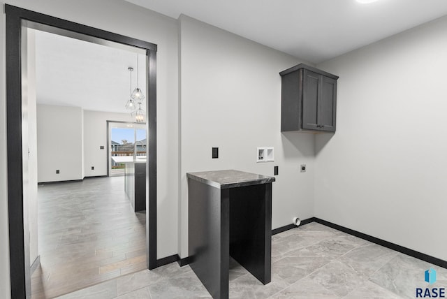 clothes washing area featuring cabinets, washer hookup, hookup for an electric dryer, and a notable chandelier