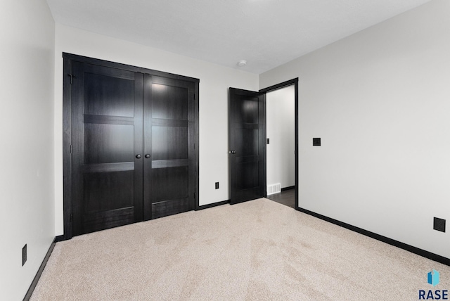 unfurnished bedroom with dark carpet and a closet