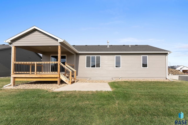 rear view of property featuring a lawn and a deck