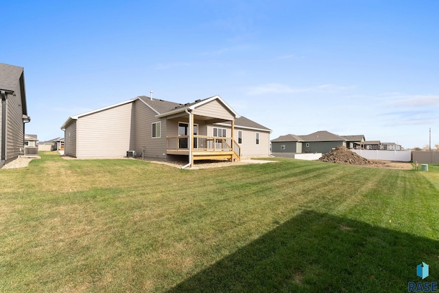 back of house featuring cooling unit, a deck, and a lawn