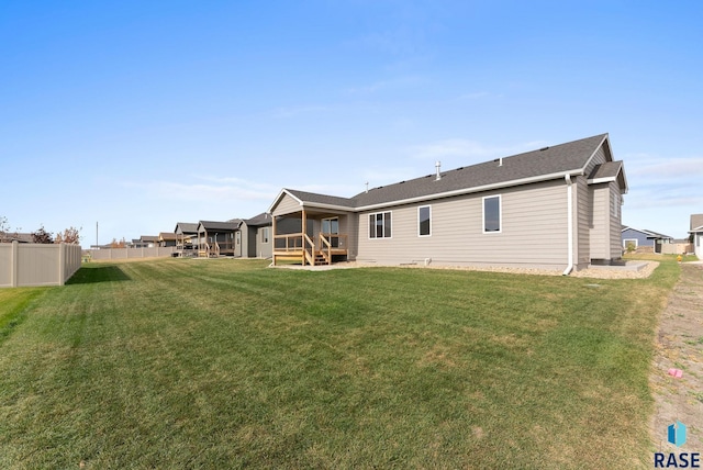 rear view of house with a wooden deck and a yard