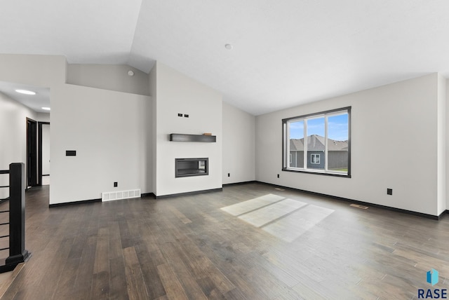 unfurnished living room featuring dark wood-type flooring and high vaulted ceiling