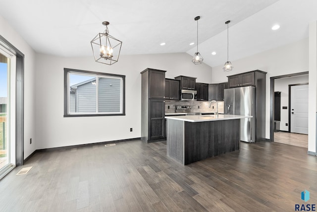 kitchen with decorative light fixtures, sink, dark wood-type flooring, stainless steel appliances, and dark brown cabinets