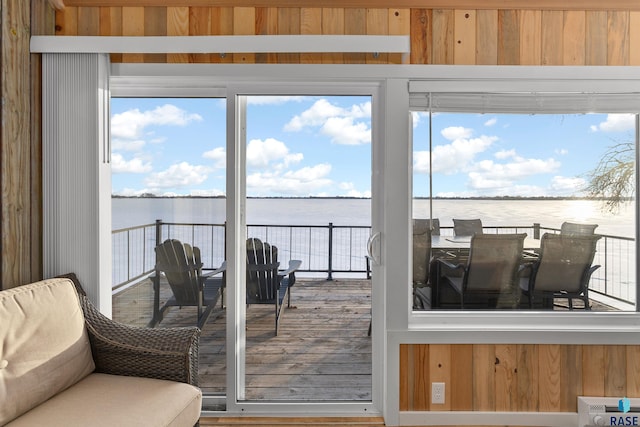 sunroom featuring a water view