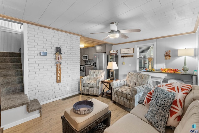 living room with crown molding, brick wall, ceiling fan, and light wood-type flooring