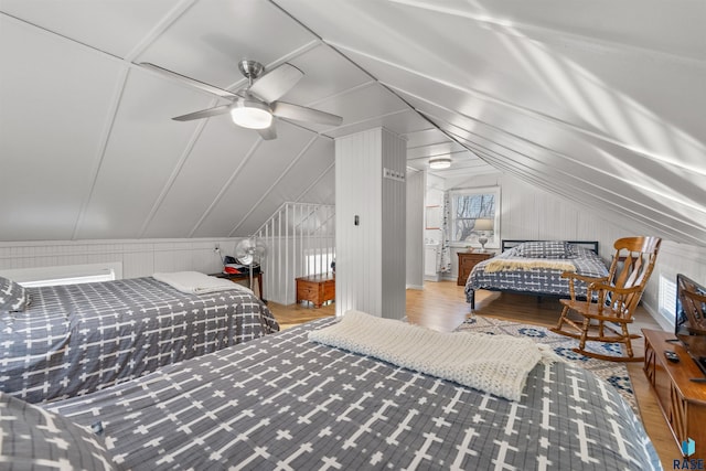 bedroom with lofted ceiling, wooden walls, and hardwood / wood-style floors