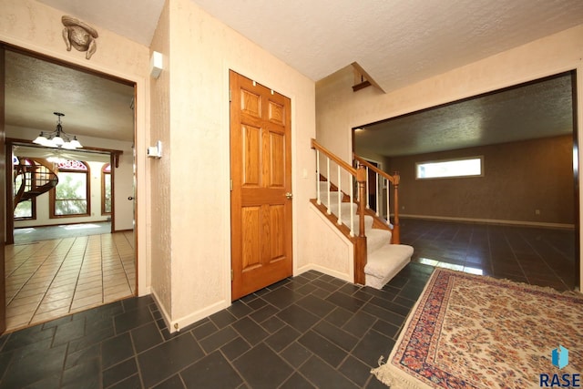 entrance foyer with a notable chandelier and a textured ceiling