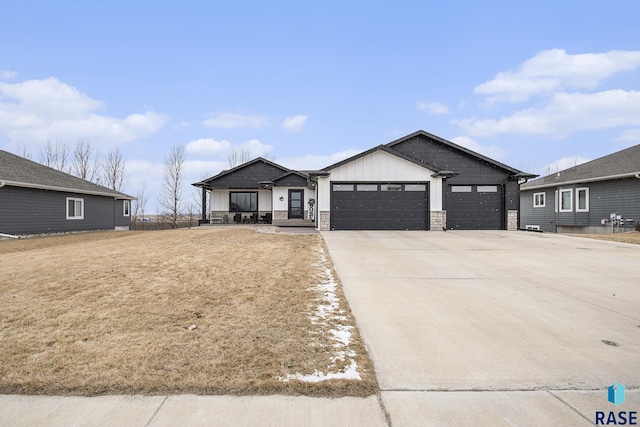 view of front of home with a porch, concrete driveway, board and batten siding, a garage, and stone siding