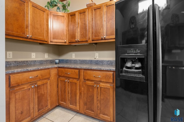 kitchen featuring light tile patterned floors and black fridge with ice dispenser