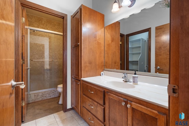 bathroom featuring vanity, tile patterned floors, a shower with door, and toilet