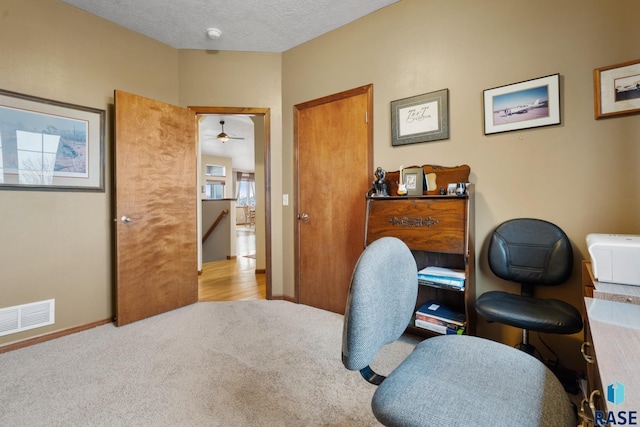 carpeted office with a textured ceiling