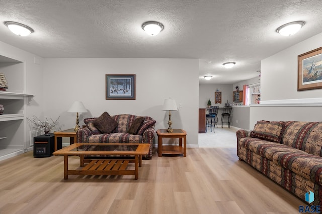 living room with a textured ceiling and light hardwood / wood-style floors