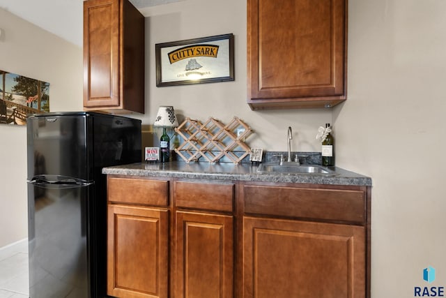 kitchen featuring black fridge and sink