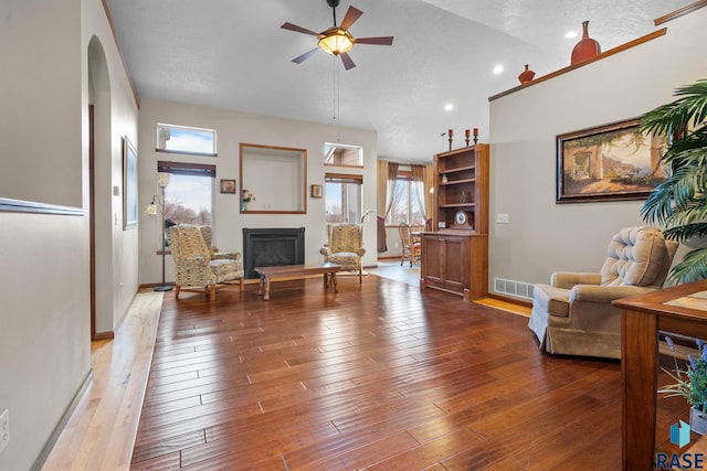 interior space with ceiling fan, wood-type flooring, and vaulted ceiling