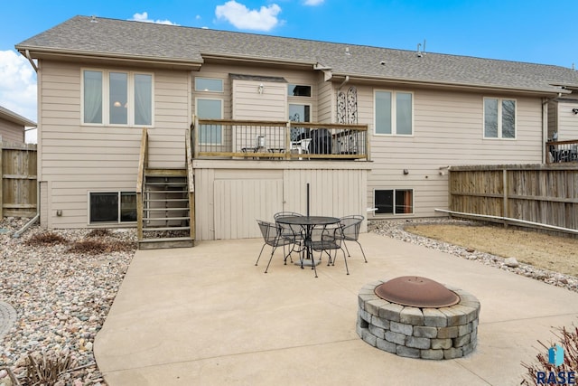 rear view of property with a balcony, a patio, and a fire pit