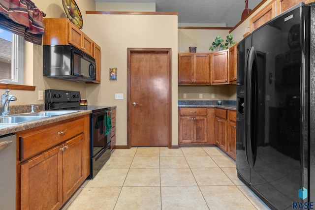 kitchen featuring sink, light tile patterned floors, and black appliances