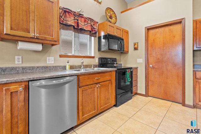 kitchen featuring sink, light tile patterned floors, and black appliances