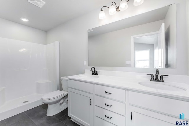 bathroom featuring vanity, a shower, tile patterned floors, and toilet