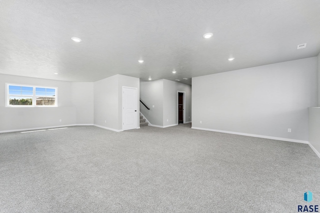 carpeted empty room featuring a textured ceiling