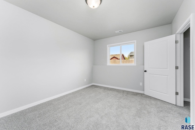 spare room featuring light carpet