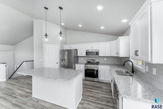 kitchen featuring pendant lighting, sink, white cabinets, a center island, and stainless steel appliances