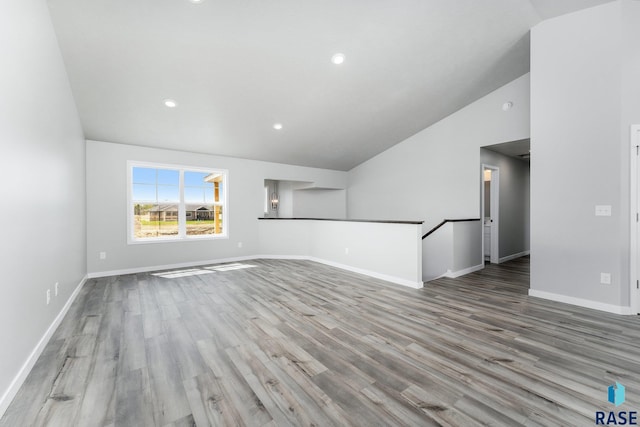 unfurnished living room with vaulted ceiling and light wood-type flooring