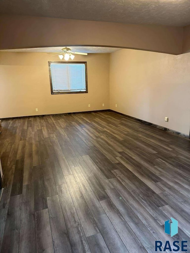 spare room featuring ceiling fan, dark hardwood / wood-style floors, and a textured ceiling