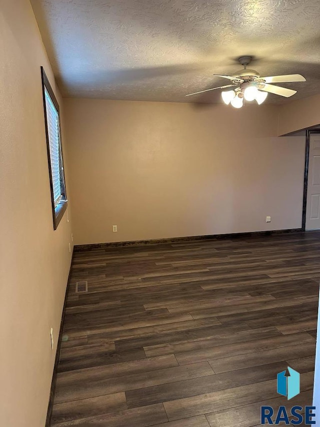 spare room featuring ceiling fan, dark hardwood / wood-style floors, and a textured ceiling