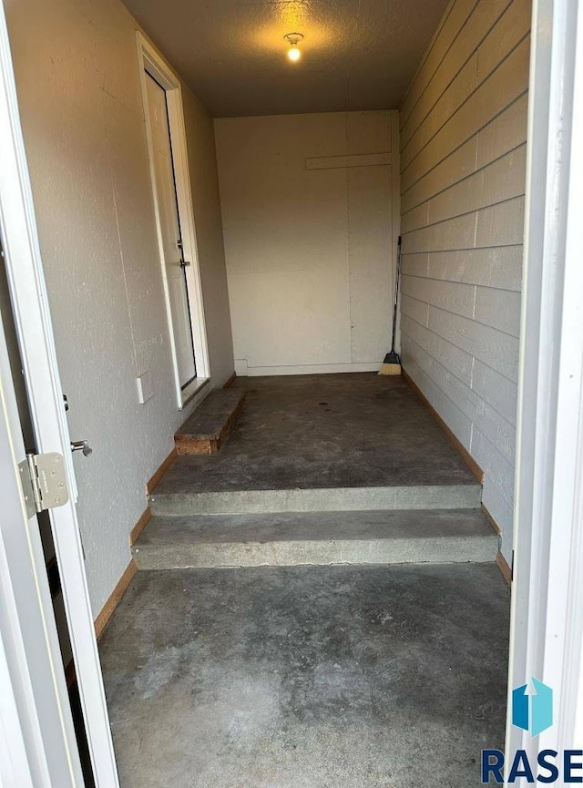 stairway with concrete flooring and a textured ceiling