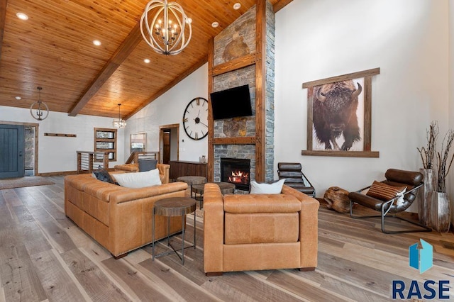 living room with an inviting chandelier, high vaulted ceiling, a fireplace, wood ceiling, and light wood-type flooring