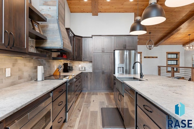 kitchen featuring pendant lighting, dark brown cabinetry, stainless steel appliances, and light stone countertops