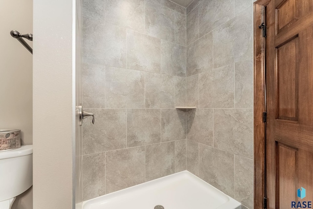 bathroom featuring toilet and tiled shower