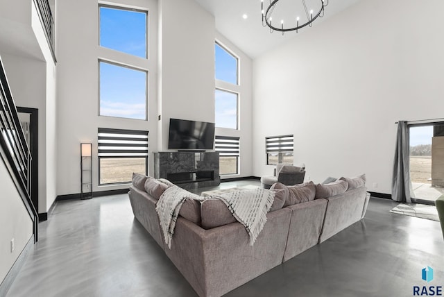 living room featuring plenty of natural light, concrete floors, and a high ceiling