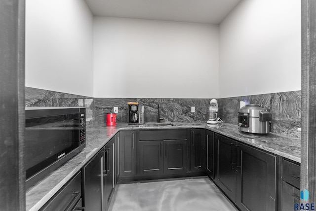 kitchen featuring light stone countertops and sink