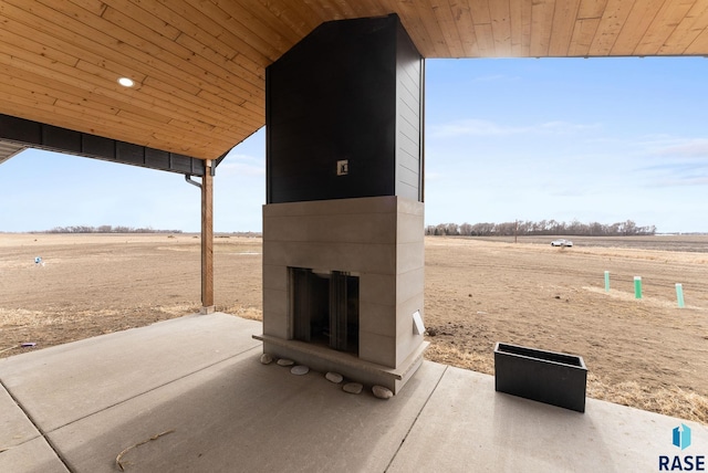 view of patio with a rural view and a fireplace