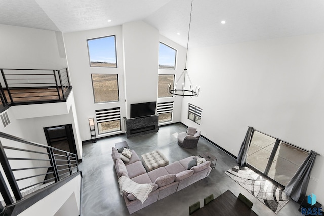 living room with a fireplace, high vaulted ceiling, and a chandelier