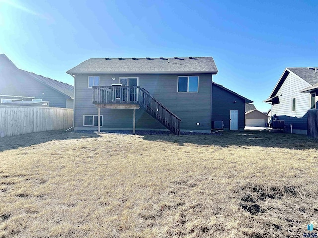 back of house with a deck and a lawn