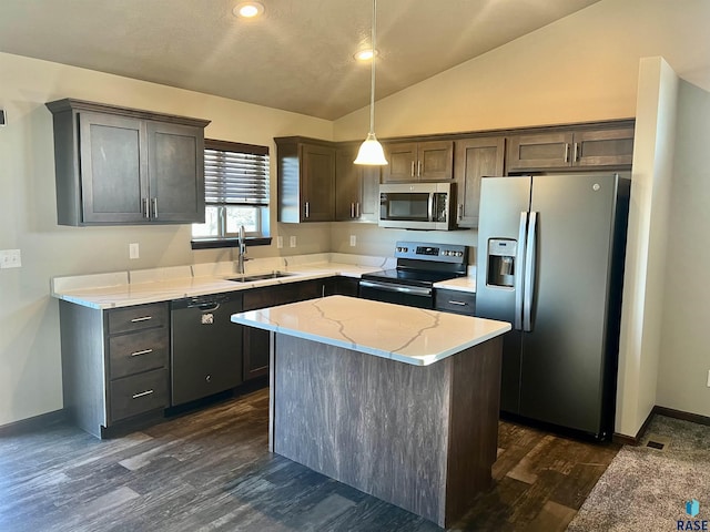 kitchen with vaulted ceiling, a kitchen island, hanging light fixtures, light stone counters, and stainless steel appliances