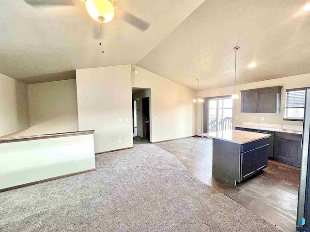 kitchen with hardwood / wood-style floors, lofted ceiling, hanging light fixtures, a center island, and ceiling fan