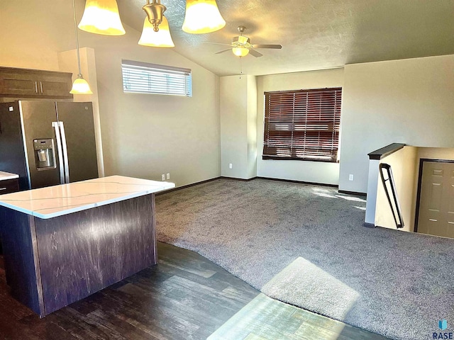 kitchen with a center island, dark colored carpet, stainless steel fridge with ice dispenser, decorative light fixtures, and vaulted ceiling