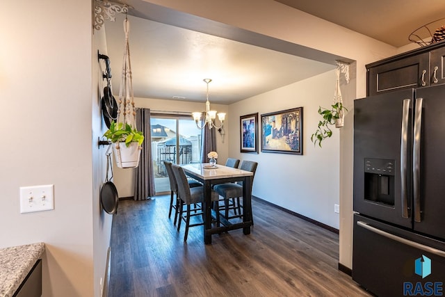 dining space featuring dark hardwood / wood-style flooring and an inviting chandelier