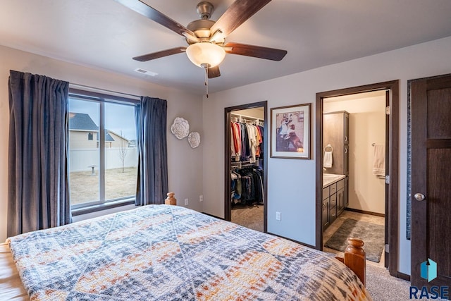 bedroom with multiple windows, a spacious closet, a closet, and ceiling fan