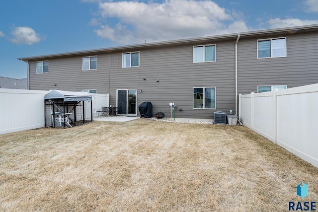 back of house with a patio, central AC, and a lawn